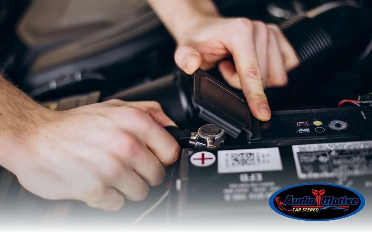 Auto repair technician checking the car battery charging system for performance and reliability under the hood